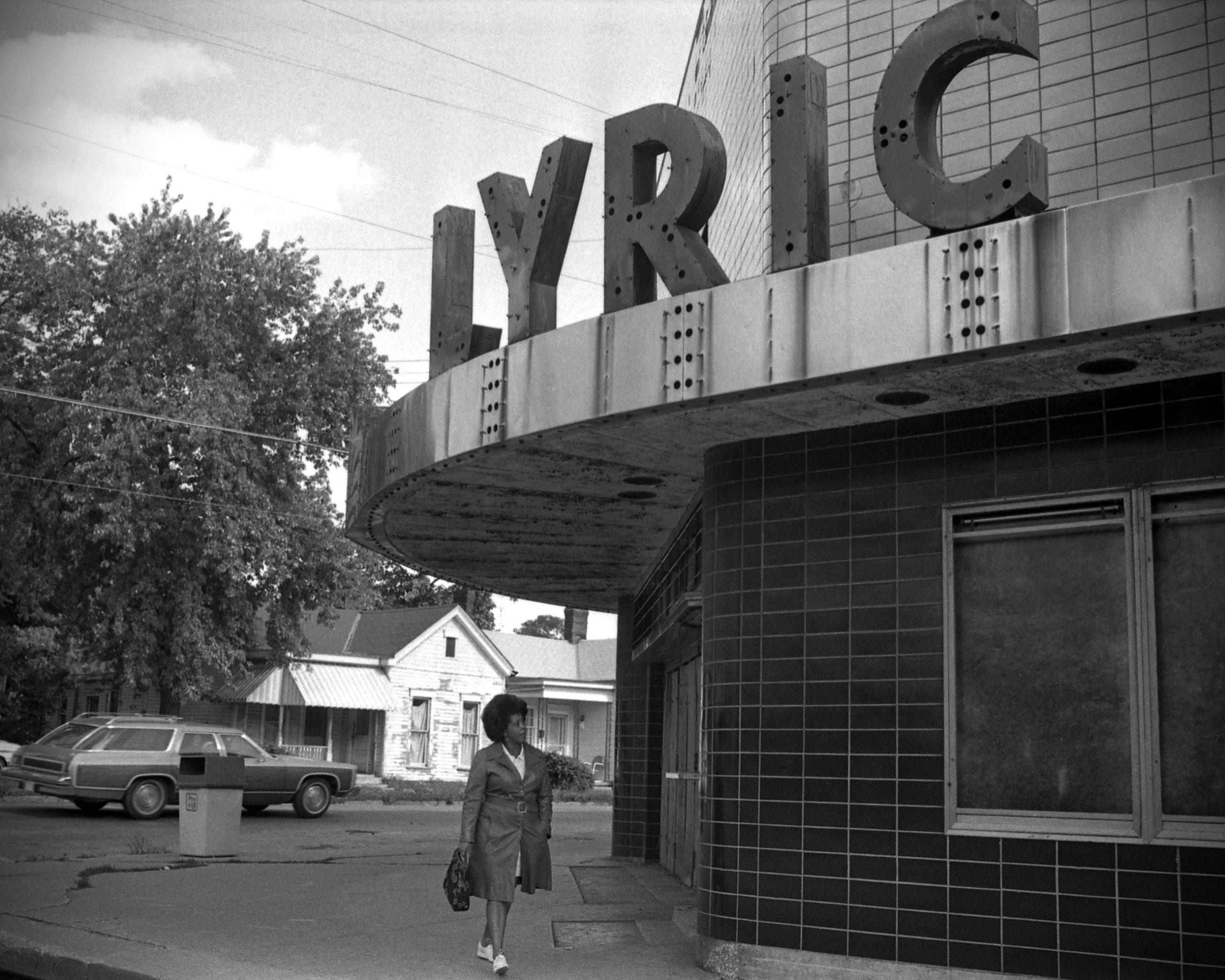 Woman standing beside the closed Lyric Theatre in 1974