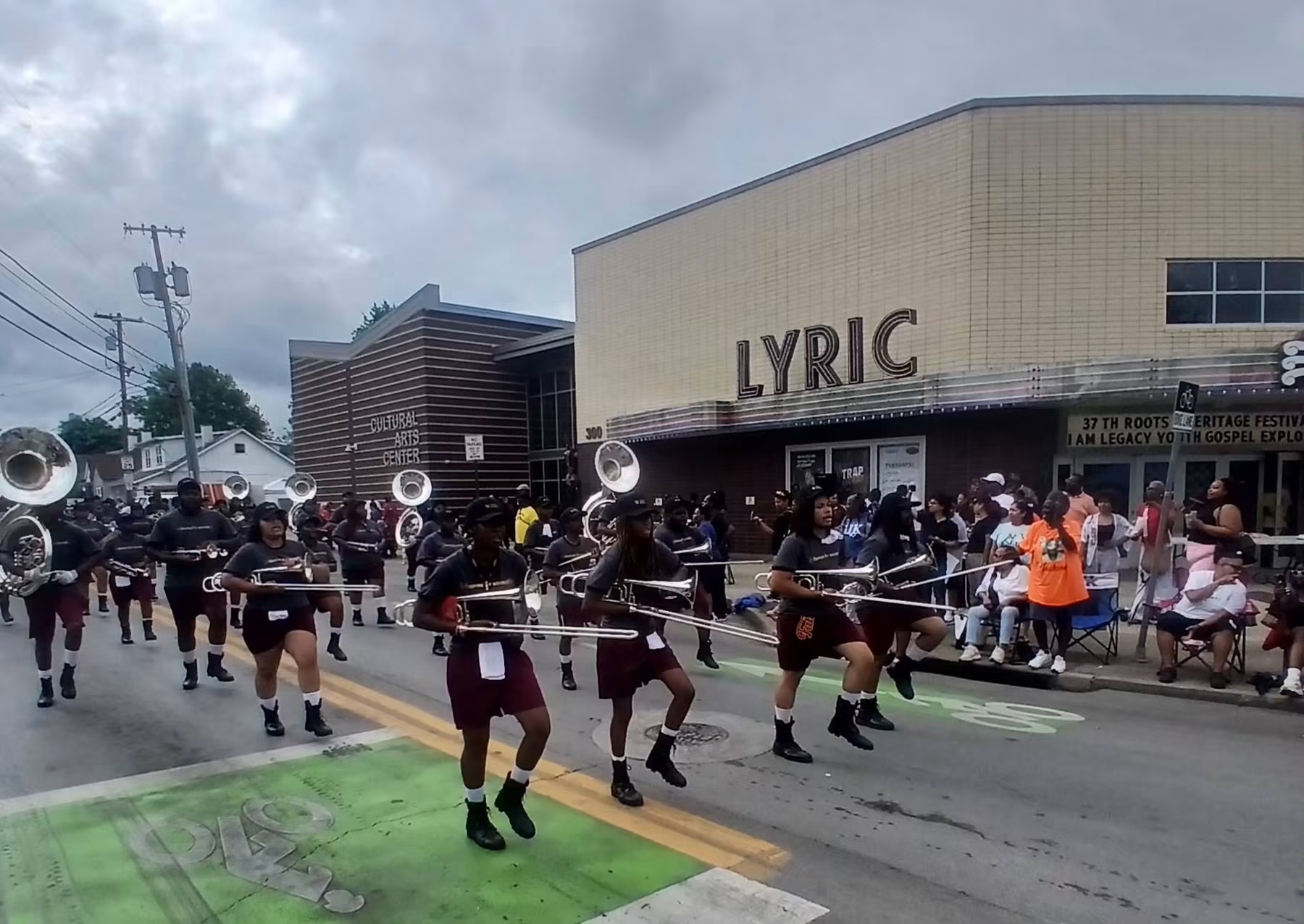 A marching band performing during the Roots and Heritage parade outside the Historic Lyric Theatre